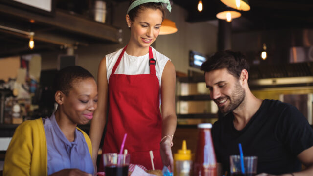 Waitress serving burger and french fries to customer