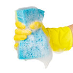 Hand holding cleaning sponge isolated on white background